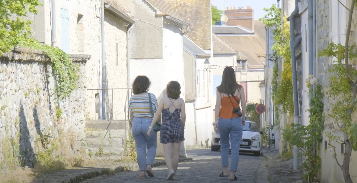 Trois personnes marchent dans une rue